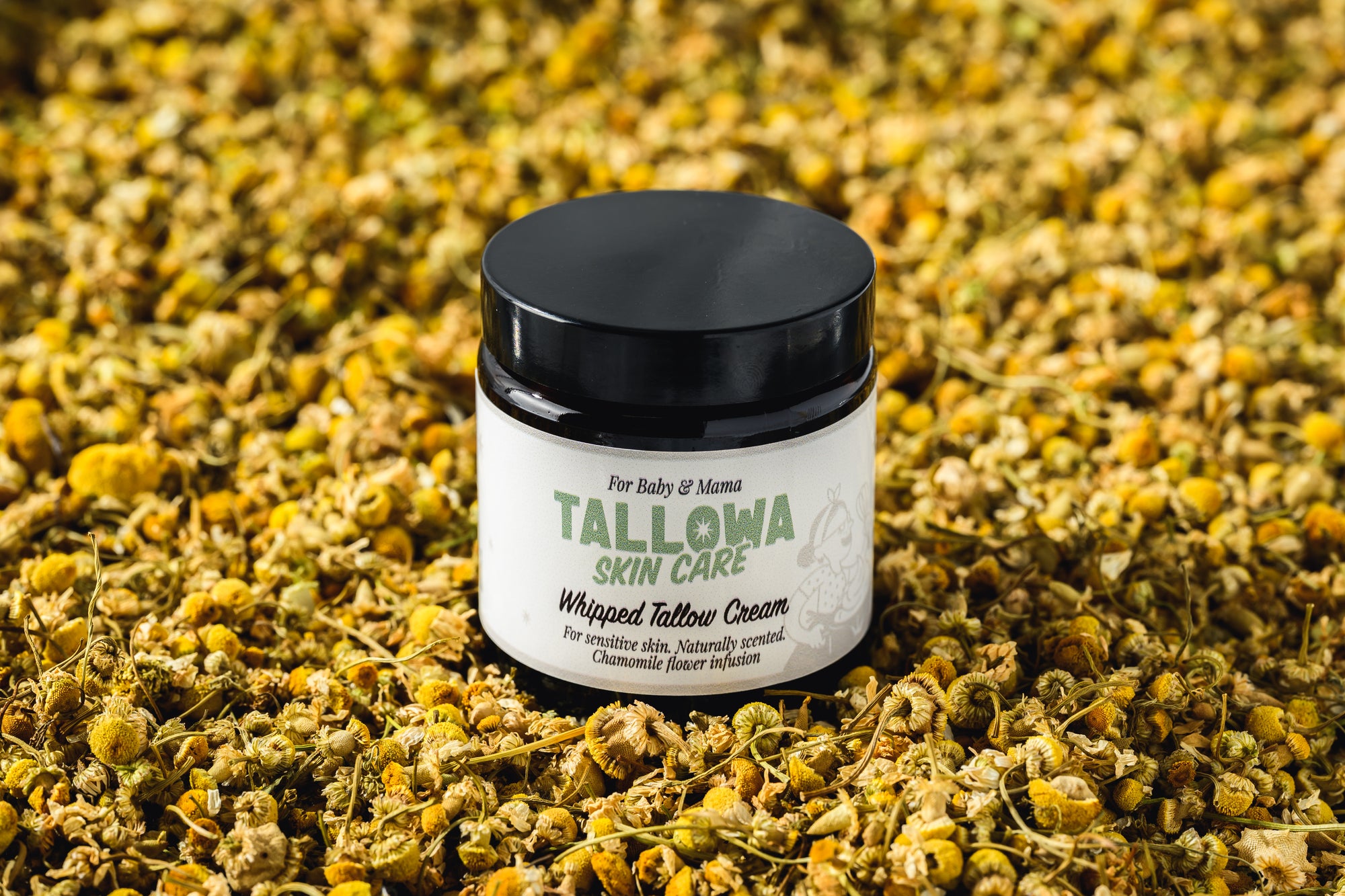 Tallowa Baby and Mama chamomile infused tallow balm surrounded by chamomile flowers for sensitive skin care in Malta Europe