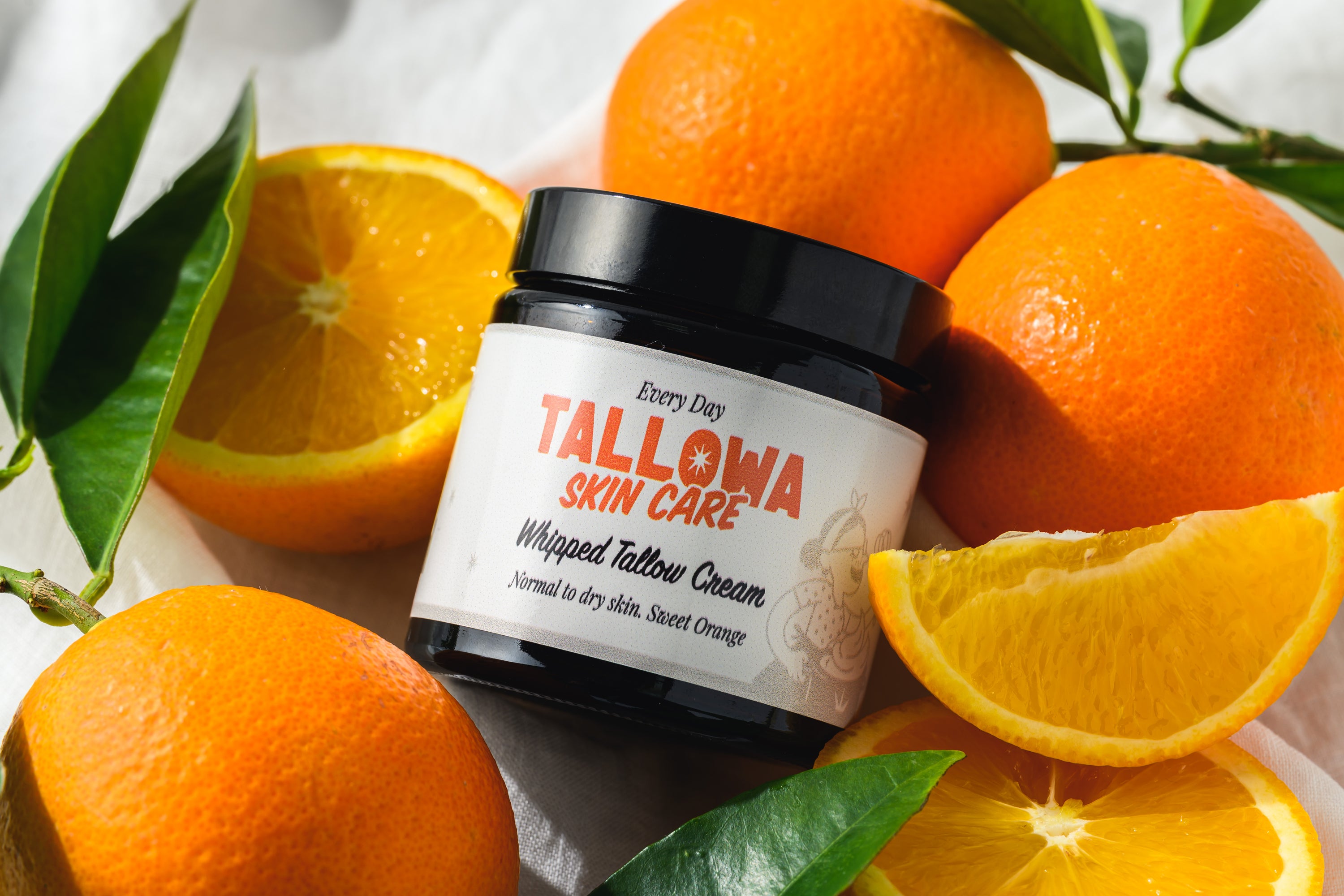 Tallowa Everyday tallow balm moisturiser surrounded by fresh oranges natural skincare flatlay in Malta Europe