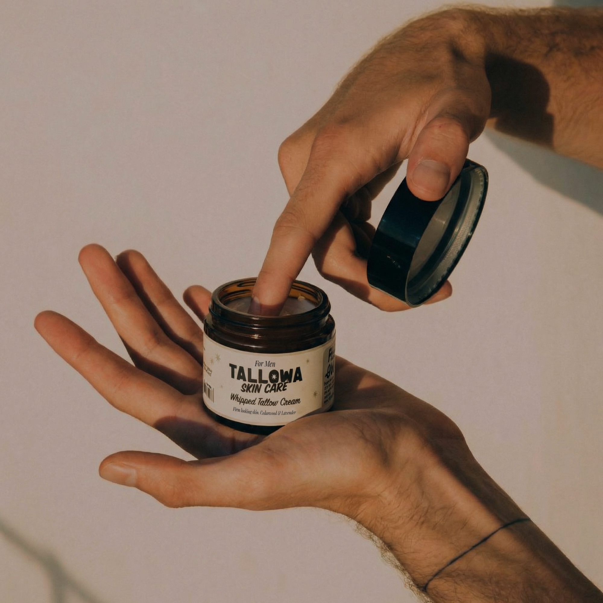 Man applying Tallowa grass fed tallow skincare balm from jar natural non toxic moisturiser for men